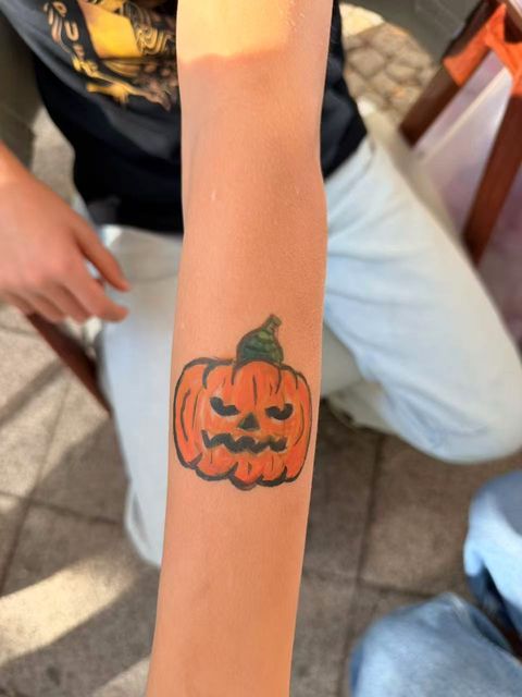Halloween pumpkin painted on an arm