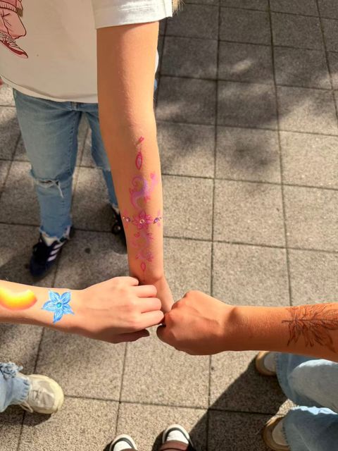 Colourful flowers and patterns painted on arms