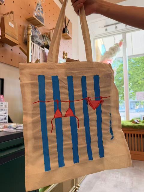 Tote bag with blue stripes and small red hearts in the studio