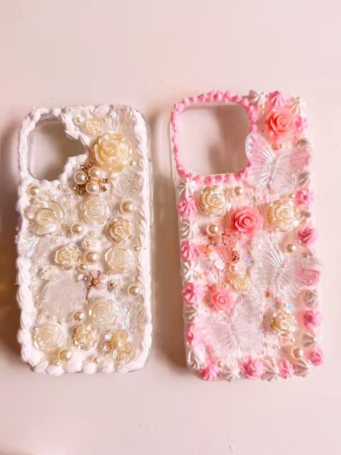 Two phone cases decorated with decoden cream, roses and pearls